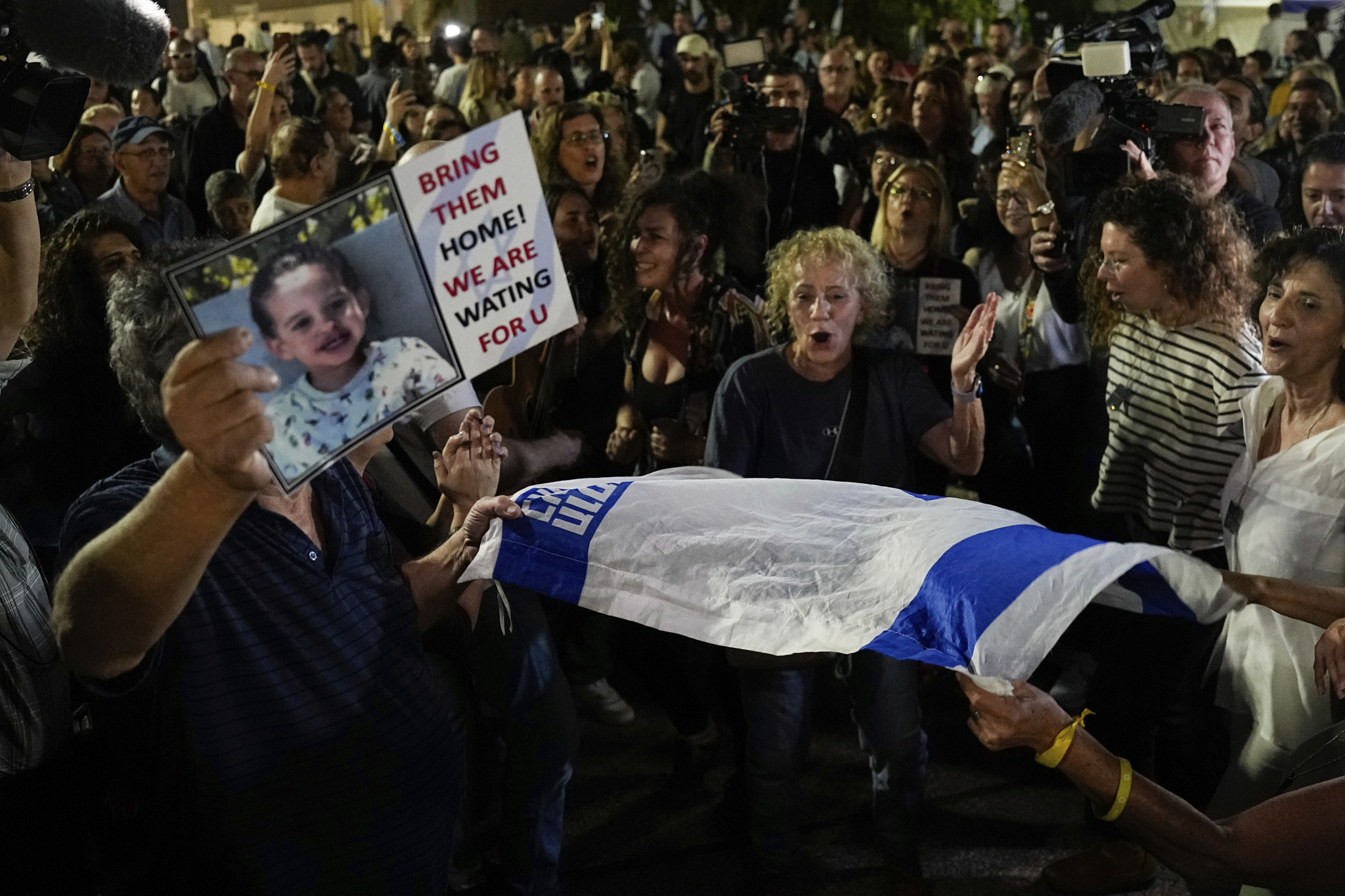 People react as they hear the news of the release of 13 Israeli hostage